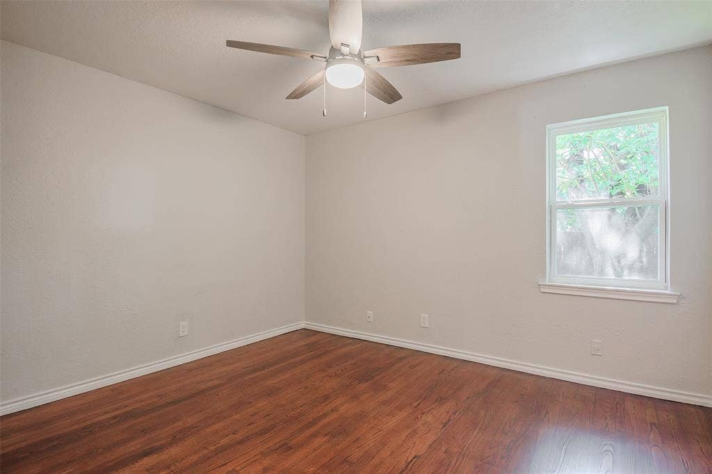 8050 Fall River Drive, Dallas, TX 75228 Room featuring wood-finish flooring, a neutral wall color palette, a ceiling fan with integrated lighting, and a single-pane window