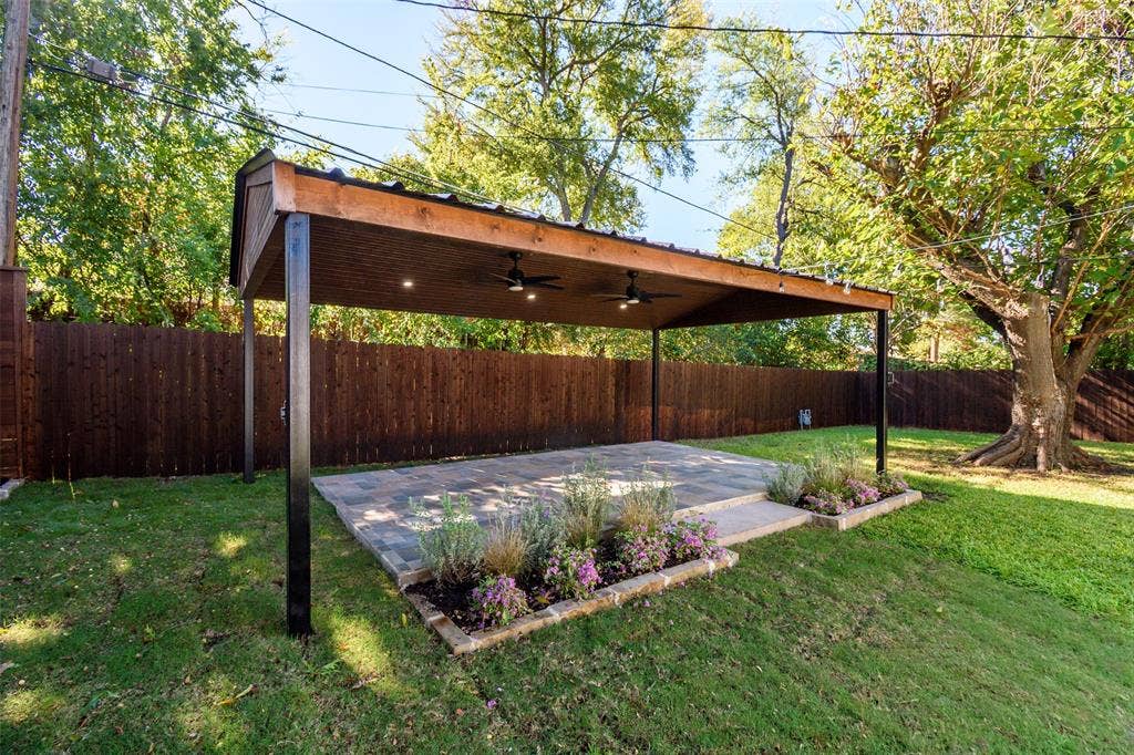8050 Fall River Drive, Dallas, TX 75228 Covered patio featuring a wood-beam structure, metal roofing, dual ceiling fans, recessed lighting, and stone paver flooring