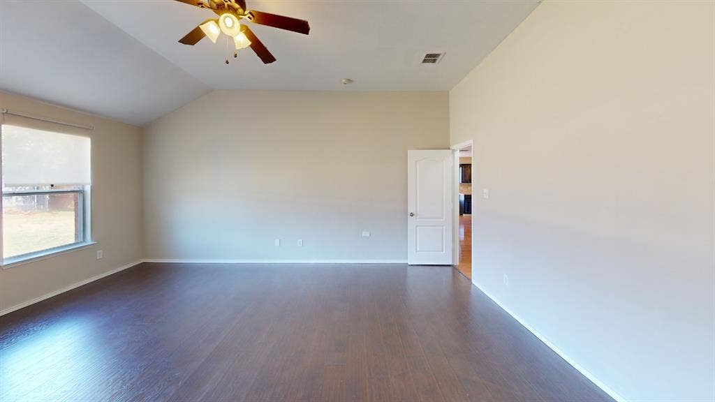 Vaulted ceilings, wood-finish flooring, and a ceiling fan with integrated lighting