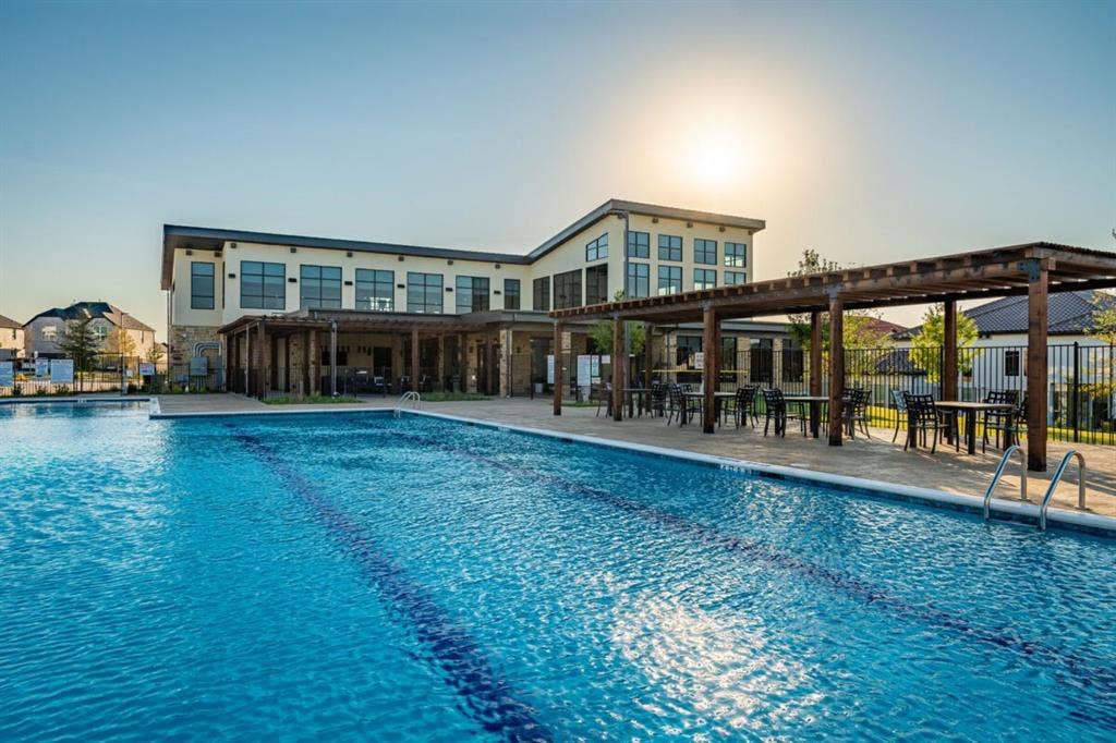 LEXINGTON Community Swimming pool featuring lane markings, stone-paver decking, and a wood-frame pergola structure