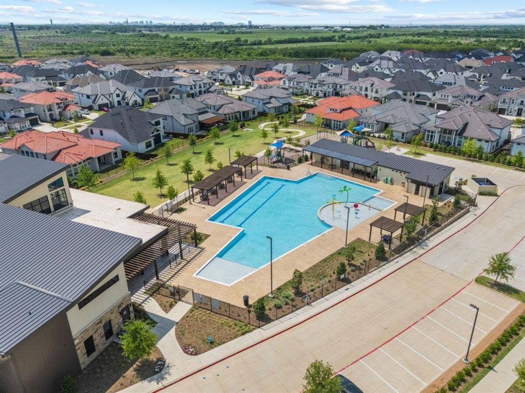 LEXINGTON Community Community recreation area featuring a lap pool, a shallow splash pad with water features, multiple shaded pergolas, and a dedicated clubhouse facility
