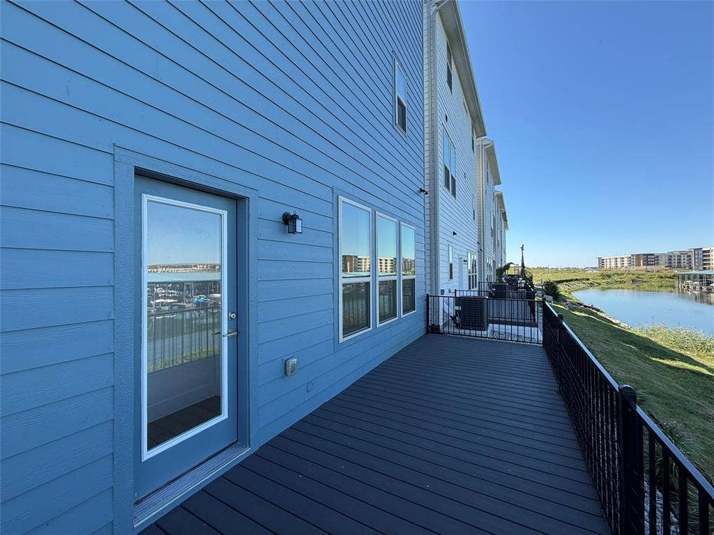 9223 Easy Street, Rowlett, TX 75088 Exterior deck featuring synthetic plank flooring, a metal railing, and blue horizontal lap siding