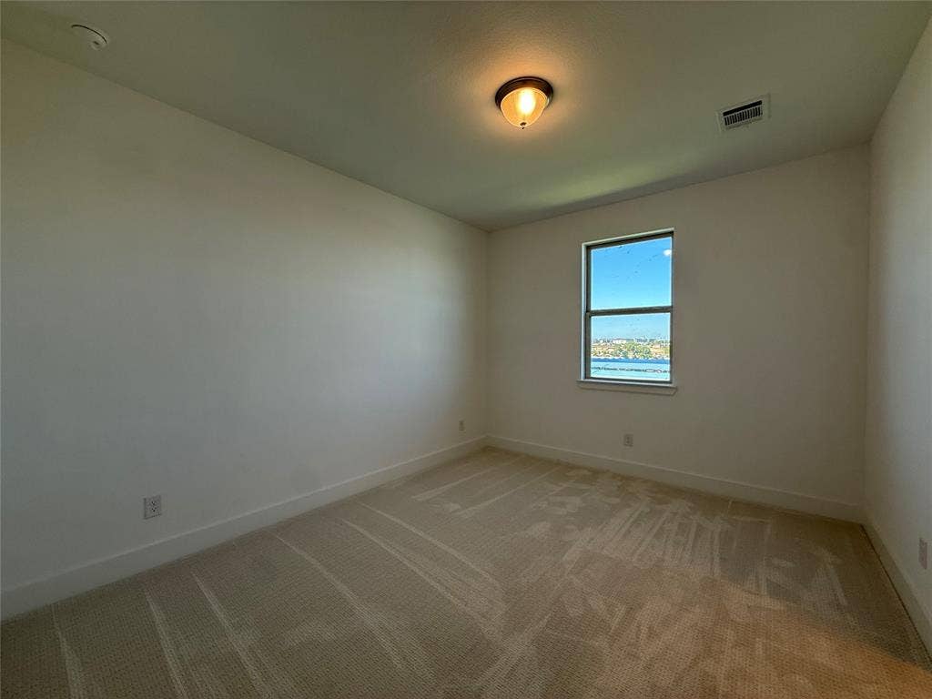 9223 Easy Street, Rowlett, TX 75088 Neutral-toned room featuring wall-to-wall carpeting, a single window, and a central flush-mount ceiling light fixture