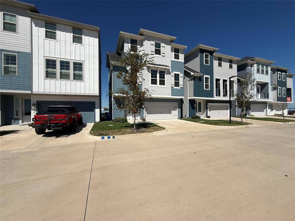9223 Easy Street, Rowlett, TX 75088 Multi-story townhome exteriors featuring vertical board-and-batten siding, lap siding, shingle accents, and attached multi-car garages