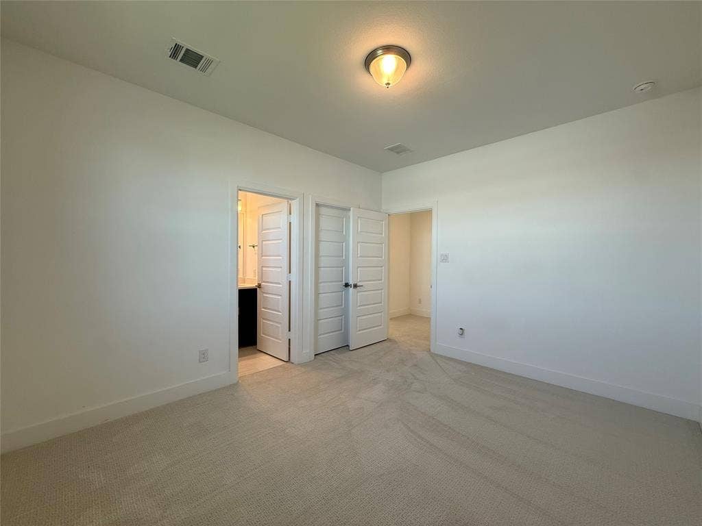 9223 Easy Street, Rowlett, TX 75088 Interior room featuring neutral-toned carpeting, multi-panel doors, and a flush-mount light fixture