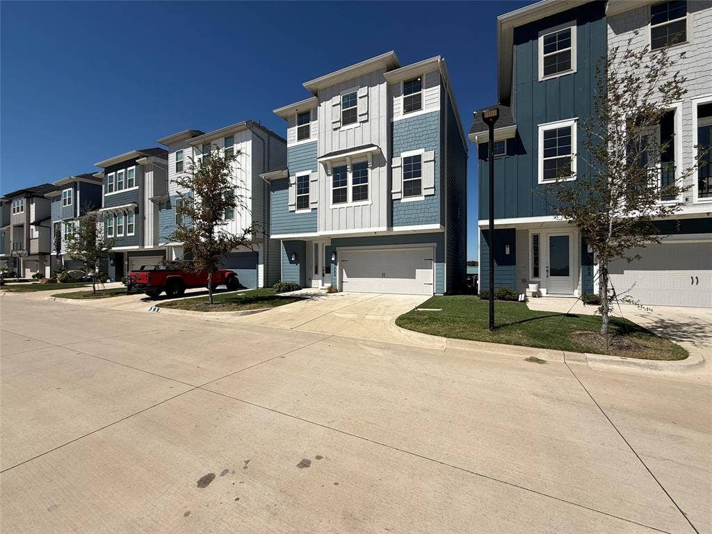 9223 Easy Street, Rowlett, TX 75088 Multi-story exterior featuring a blend of board-and-batten and horizontal siding, attached two-car garage, and concrete driveway