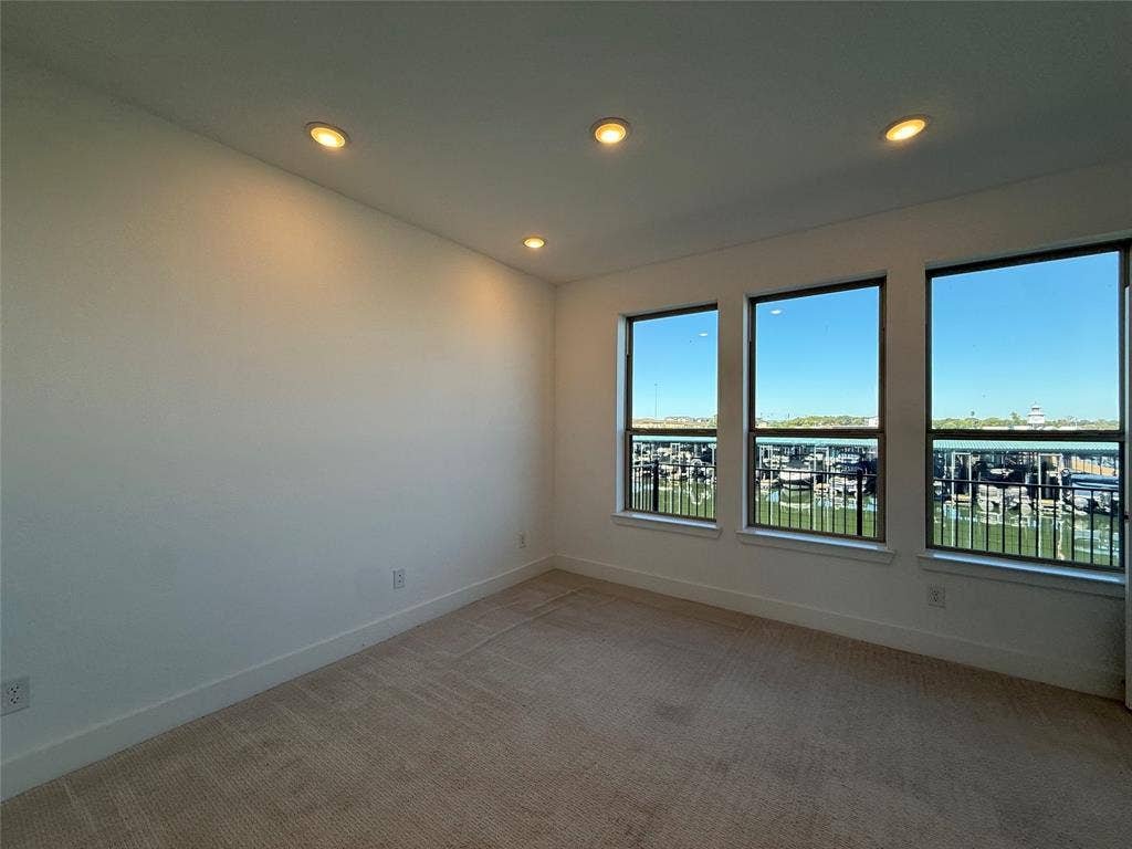 9223 Easy Street, Rowlett, TX 75088 Neutral wall palette featuring recessed lighting, carpeting, and three oversized windows with a water and marina outlook