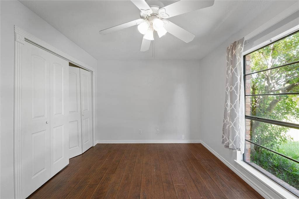 9214 Vagas Drive, Rowlett, TX 75088 Unfurnished bedroom featuring a closet, dark wood-type flooring, and ceiling fan