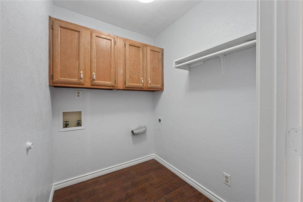 9214 Vagas Drive, Rowlett, TX 75088 Laundry area with washer hookup, dark wood-type flooring, electric dryer hookup, and cabinets