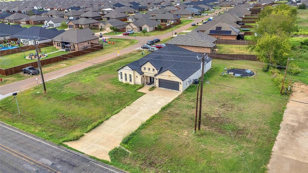 2002 Clay Street, Mabank, TX 75147 Aerial view of the front, attached garage and driveway with the neighborhood beyond