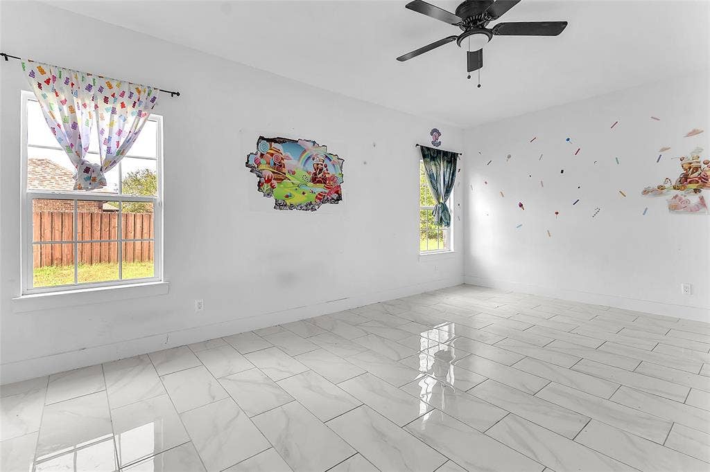 2002 Clay Street, Mabank, TX 75147 Bedroom with two windows overlooking the fenced yard, ceiling fan and tile flooring