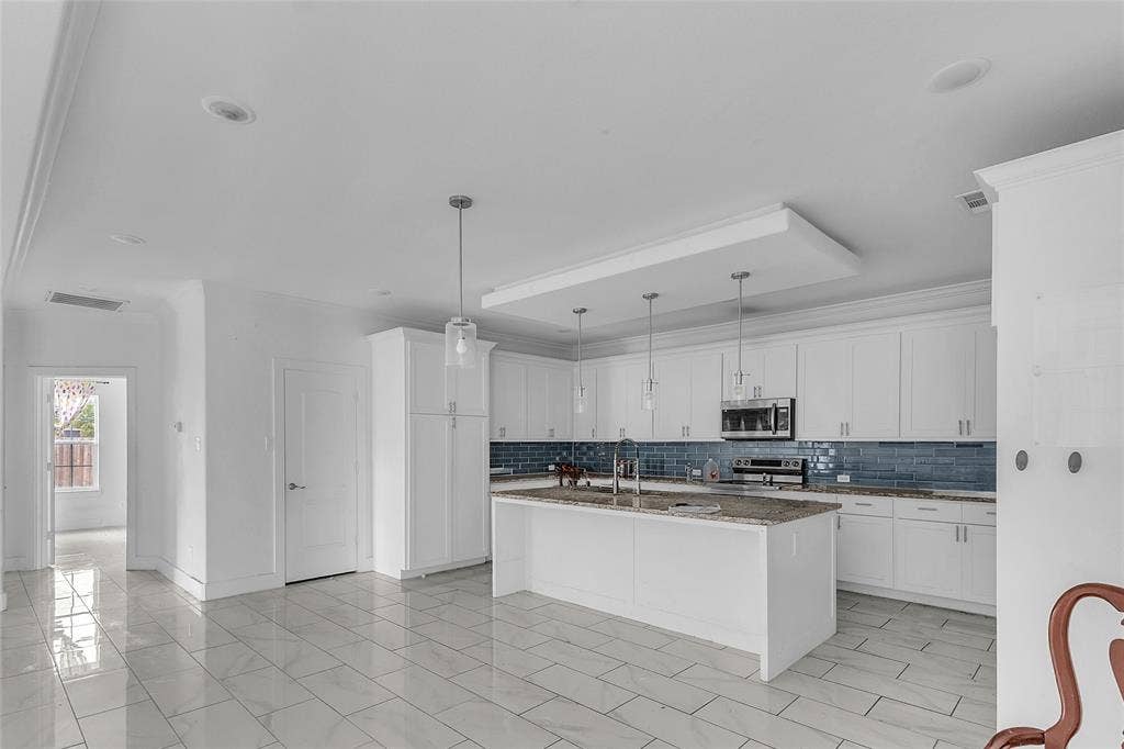 2002 Clay Street, Mabank, TX 75147 Kitchen with island, white shaker cabinets, blue tile backsplash and stainless appliances