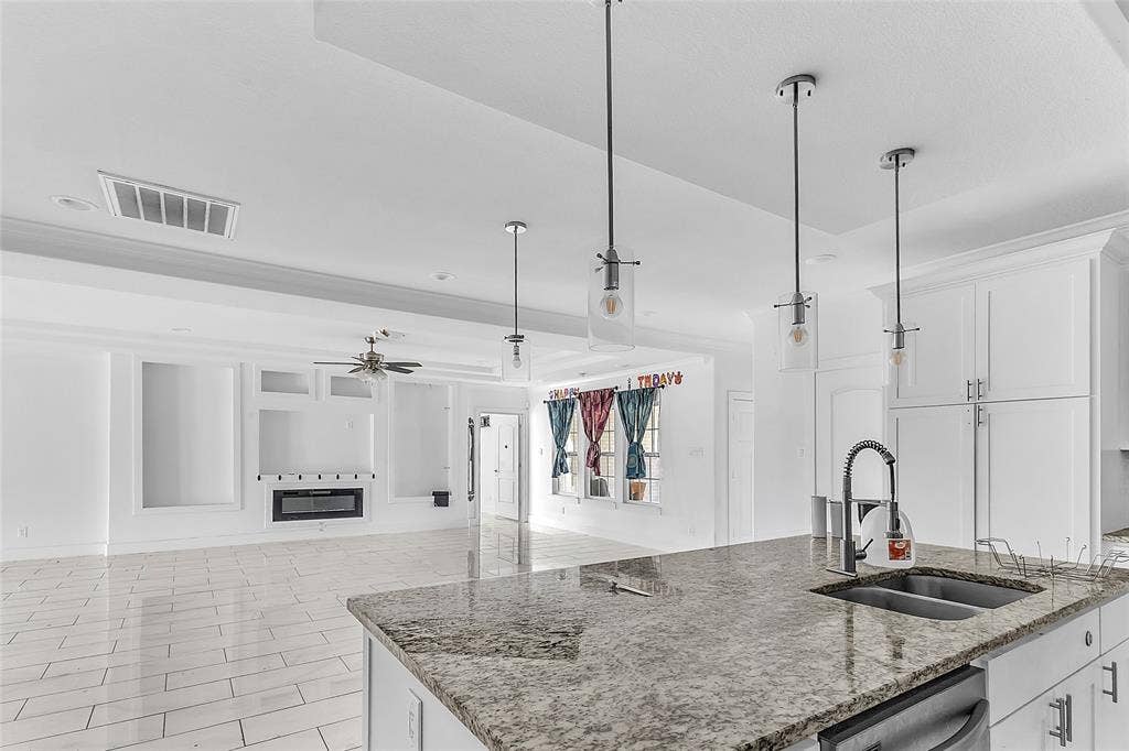 2002 Clay Street, Mabank, TX 75147 Kitchen island with granite-look counters, double sink and pendant lights opens to the living area