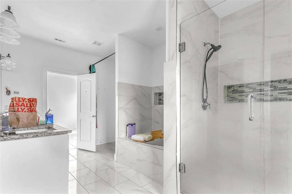 2002 Clay Street, Mabank, TX 75147 Primary bath with glass walk-in shower, separate tub area and granite-look vanity