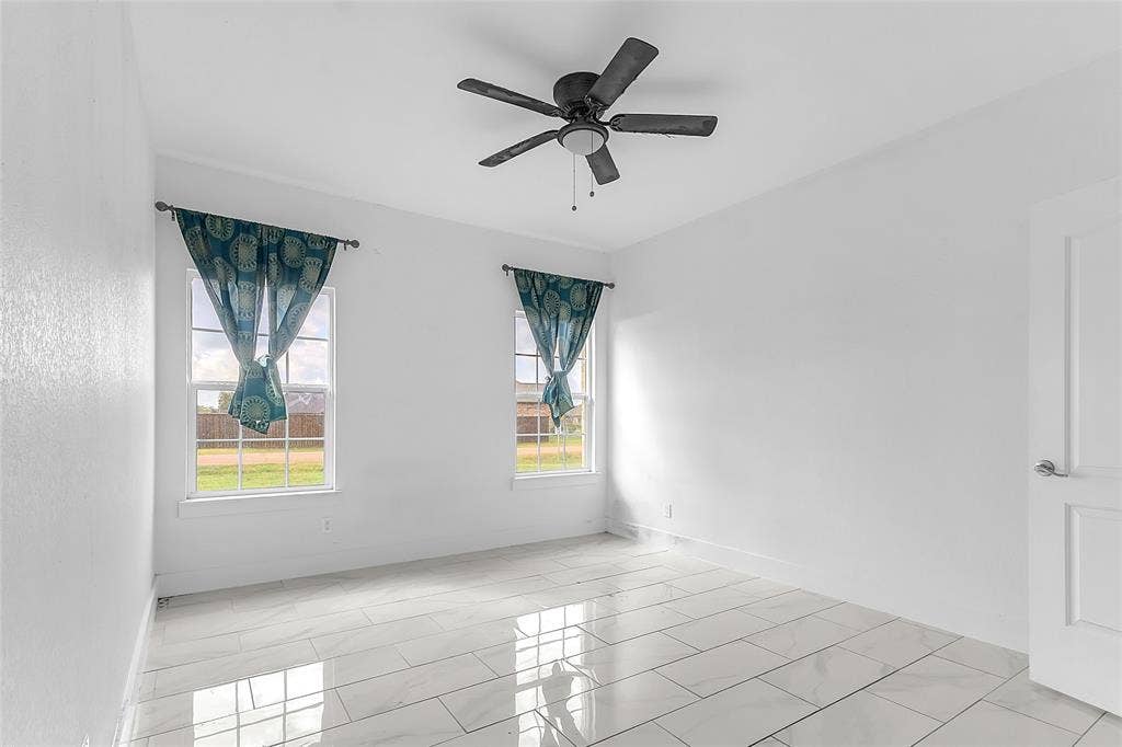 2002 Clay Street, Mabank, TX 75147 Bedroom with two windows, ceiling fan, tile flooring and a neutral white finish