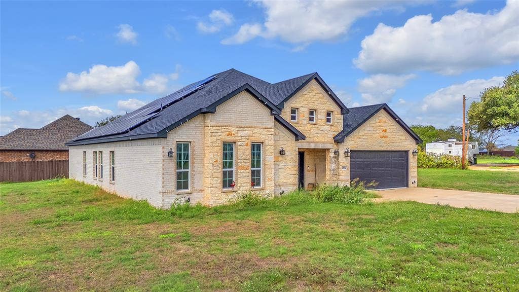 2002 Clay Street, Mabank, TX 75147 Stone and brick exterior with gabled roofline and two-car garage under blue skies