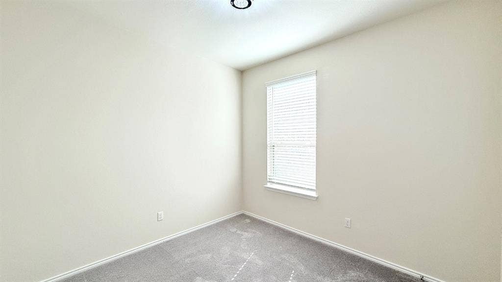 113 Onna Street, Taylor, TX 76574 Neutral interior featuring wall-to-wall carpeting, a single-pane window with integrated blinds, and a flush-mount ceiling light fixture