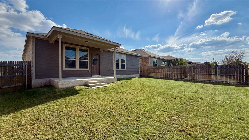 113 Onna Street, Taylor, TX 76574 Single-story exterior featuring masonry stone veneer, an attached two-car garage, and concrete driveway