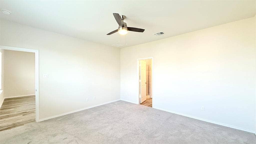 113 Onna Street, Taylor, TX 76574 Spacious interior featuring high ceilings, neutral wall tones, carpeted flooring, and a central ceiling fan with an integrated light fixture