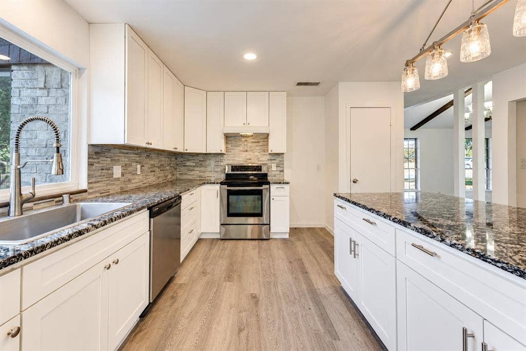 Kitchen has new cabinetry that goes all the way to ceiling, new appliances, recessed lighting, wide space for island, window in kitchen, pantry.