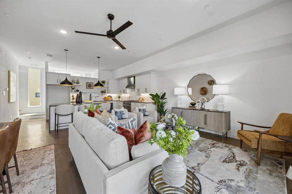 1901 N Carroll Avenue, #104, Dallas, TX 75204 Open-concept living space featuring high ceilings, wood-finish flooring, a kitchen island with pendant lighting, and modern cabinetry