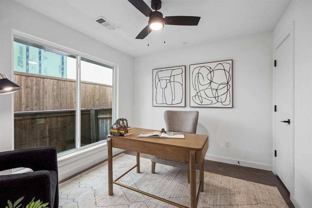 1901 N Carroll Avenue, #104, Dallas, TX 75204 Room featuring dark wood-finish flooring, a matte black ceiling fan with integrated lighting, and a large window