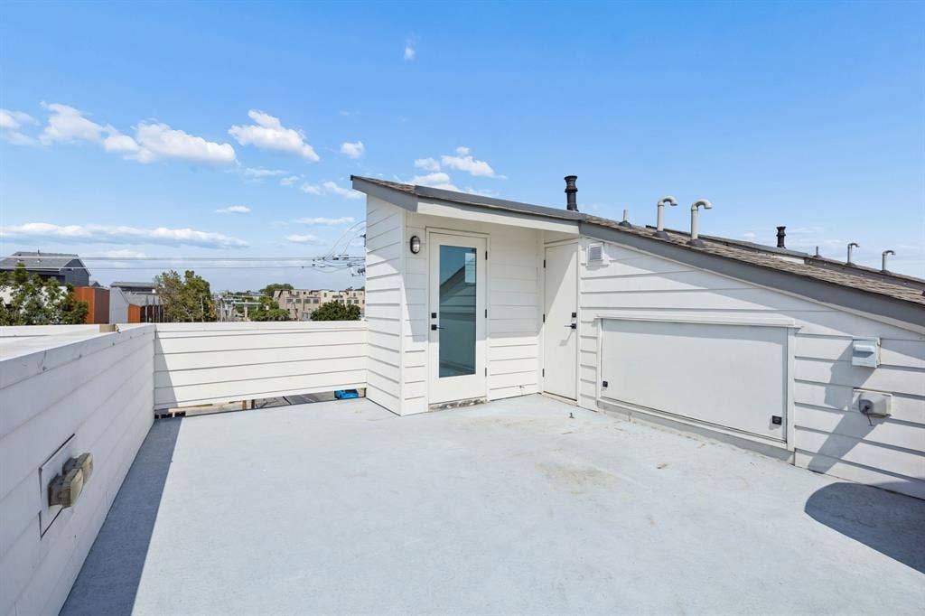 1901 N Carroll Avenue, #104, Dallas, TX 75204 Rooftop deck featuring horizontal siding, integrated wall-mounted lighting, and a glass-paneled access door