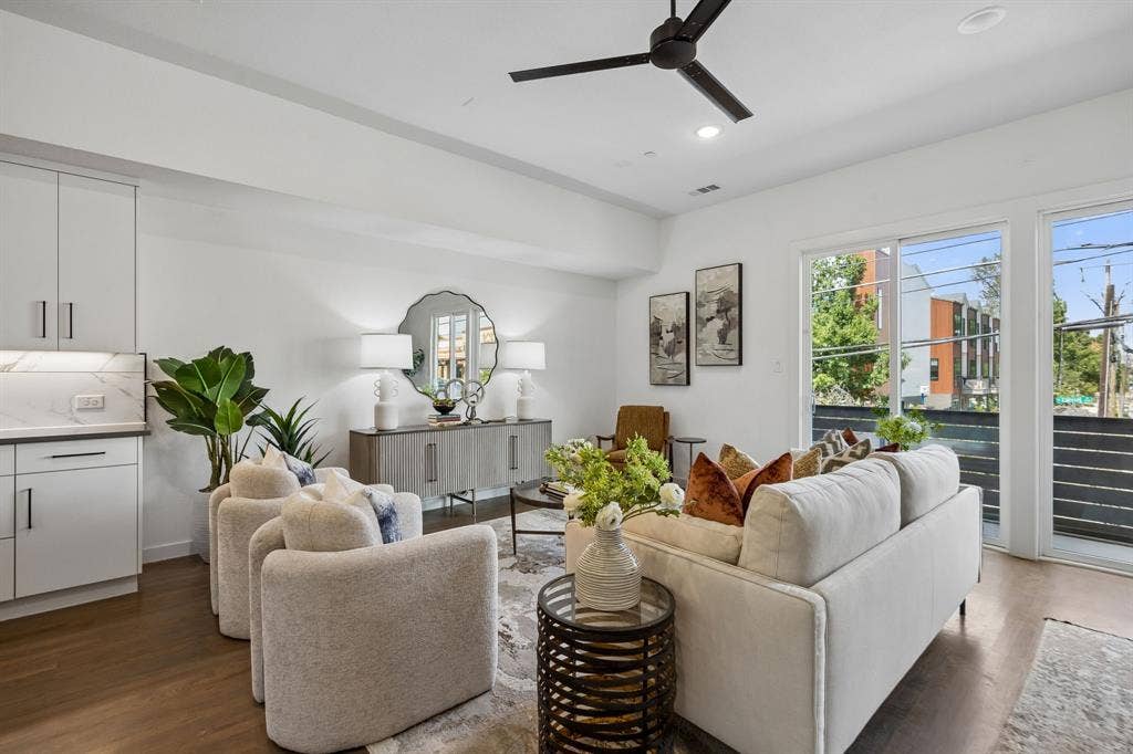 1901 N Carroll Avenue, #104, Dallas, TX 75204 Open-concept interior featuring wood-finish flooring, a matte black ceiling fan, recessed lighting, white cabinetry with stone-finish countertops, and sliding glass doors with metal railings