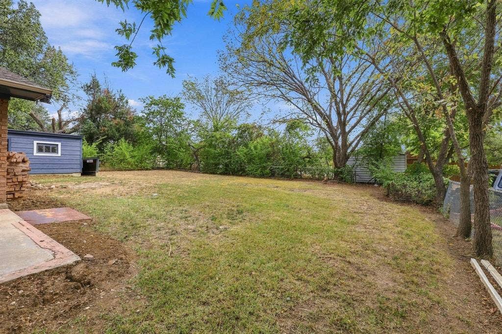 Large grassed backyard with trees