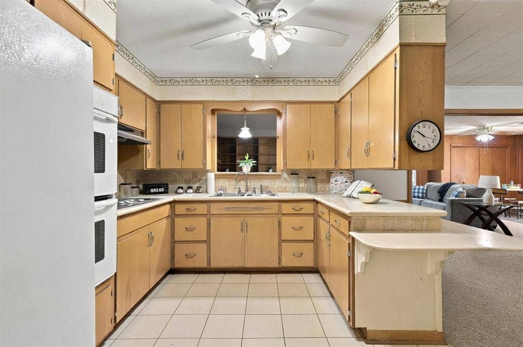 Built in cabinetry with double oven, stove top, plenty of cabinetry and a multi-level peninsula with a countertop extension