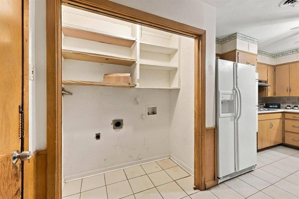 Utility area featuring custom open shelving,  and dedicated hookups, with cabinetry