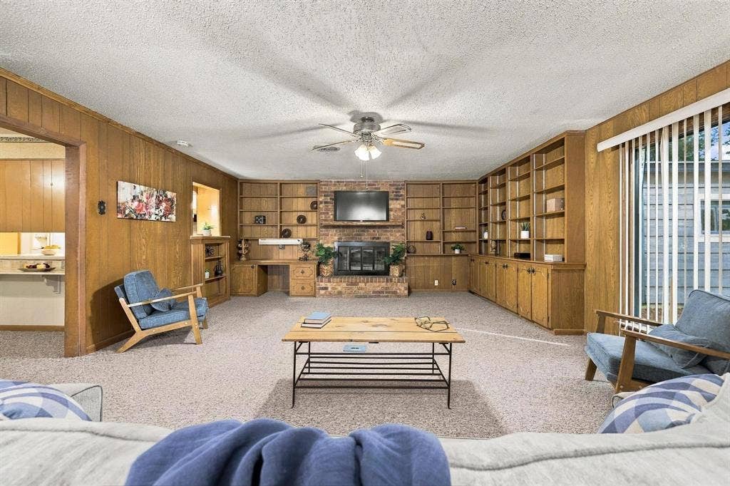 Cozy brick fireplace, custom built in cabinetry and entertainment center