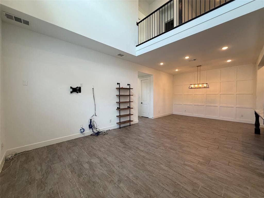 12905 Yale Court, Frisco, TX 75035 Two-story ceiling height, wood-finish flooring, grid-pattern wall molding, recessed lighting, and metal spindle railing