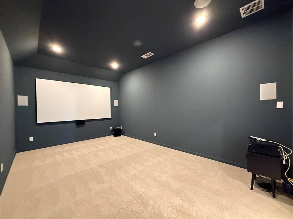 12905 Yale Court, Frisco, TX 75035 Interior room featuring a tray ceiling, recessed lighting, wall-mounted projection screen, built-in wall speakers, and neutral carpeting