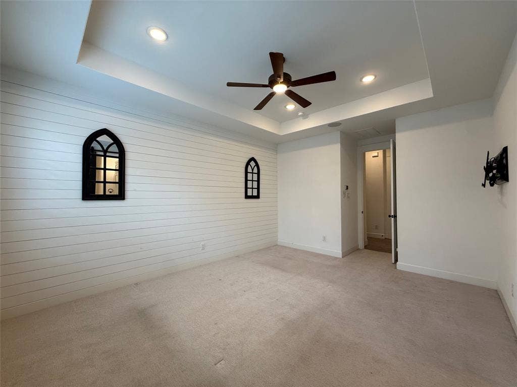 12905 Yale Court, Frisco, TX 75035 Tray ceiling with recessed lighting, shiplap accent wall, twin arched decorative wall fixtures, and integrated ceiling fan