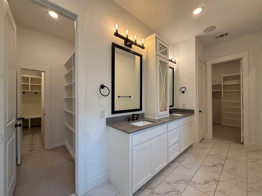 12905 Yale Court, Frisco, TX 75035 Double vanity with quartz countertops, custom white cabinetry, black hardware, and large-format tiled flooring