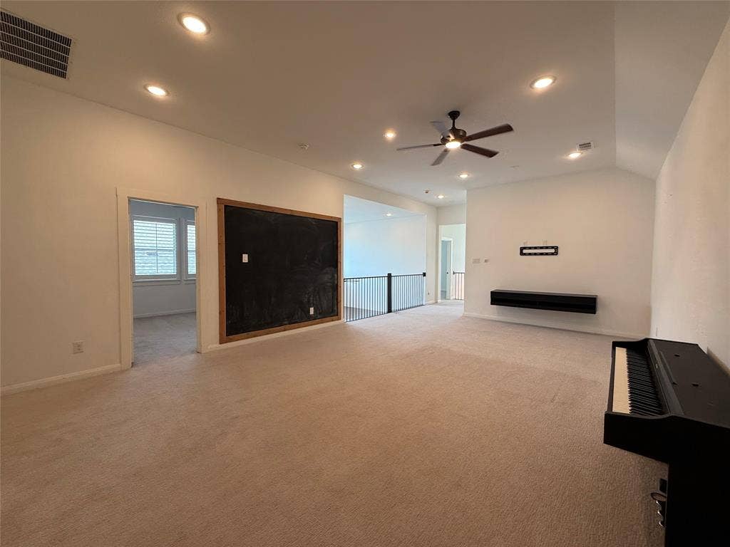 12905 Yale Court, Frisco, TX 75035 Vaulted ceilings with recessed lighting, integrated wall-mounted cabinetry, ceiling fan, and metal baluster railing
