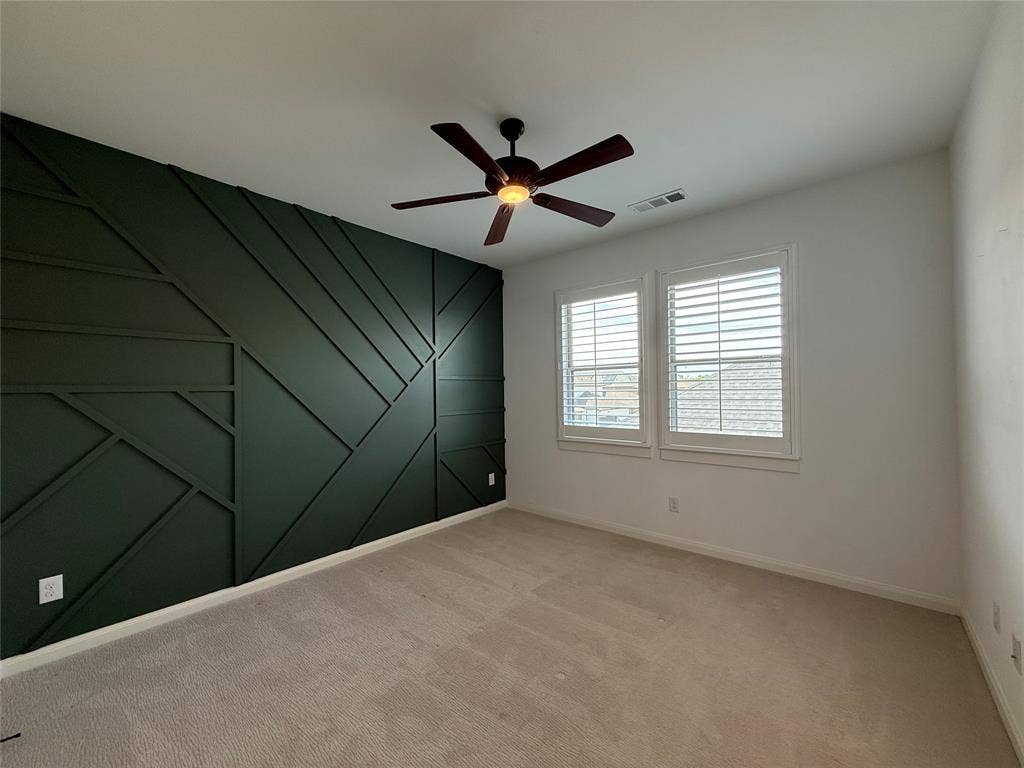 12905 Yale Court, Frisco, TX 75035 Geometric accent wall in dark finish, neutral carpeting, and shutter-style window coverings, accented by a ceiling fan with integrated light fixture
