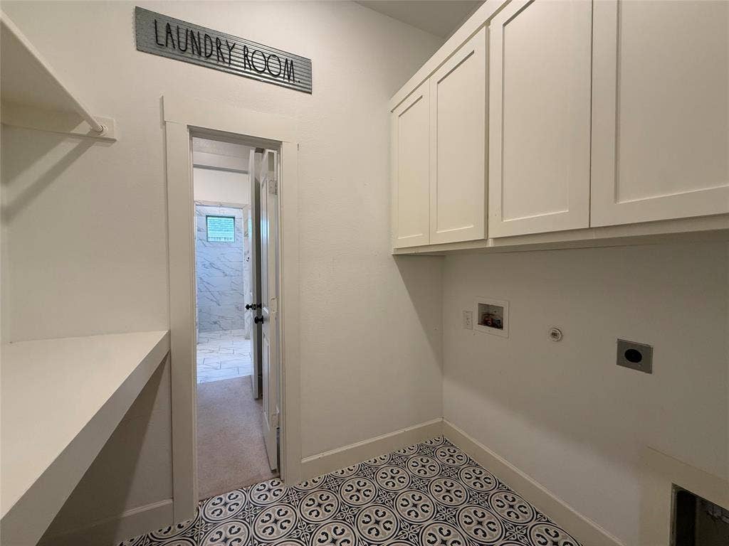 12905 Yale Court, Frisco, TX 75035 Utility area featuring patterned tile flooring, built-in white upper cabinetry, a fixed shelving unit, and plumbing hookups