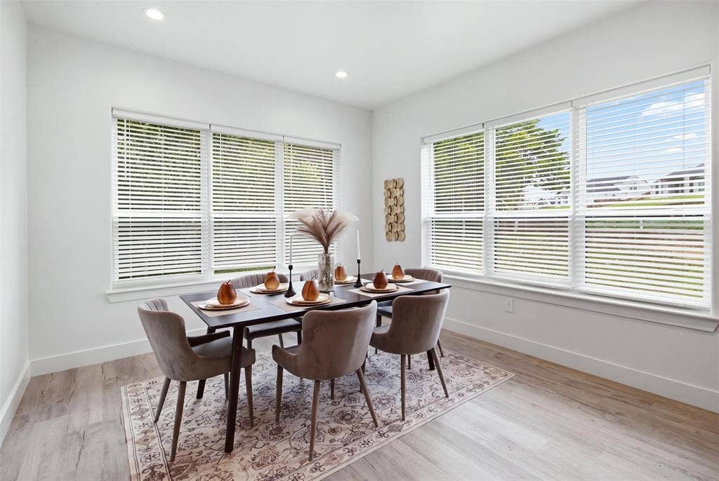 Bright room featuring wood-finish flooring, recessed lighting, and multiple large windows with horizontal blinds
