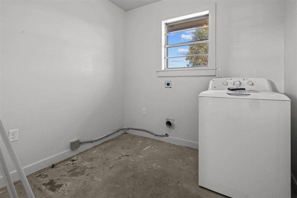 17014 Woodcrest Circle, Lindale, TX 75771 Utility space featuring an exposed concrete floor, white interior walls, a single-pane window, and dedicated laundry hookups