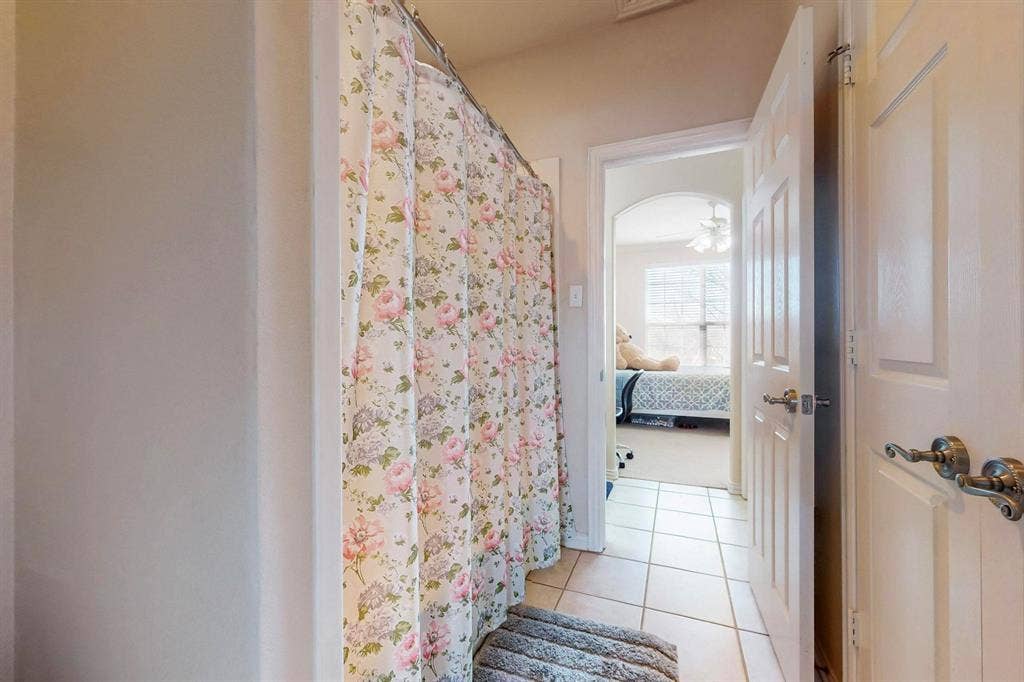 2606 Rue De Ville, Irving, TX 75038 Ceramic tile flooring, six-panel interior doors with metallic lever handles, and a shower alcove
