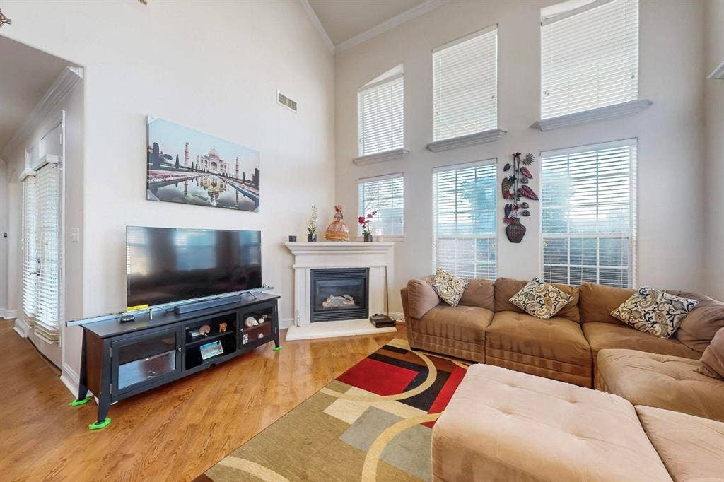 2606 Rue De Ville, Irving, TX 75038 Vaulted ceilings, expansive windows, and a classic fireplace with a decorative mantel