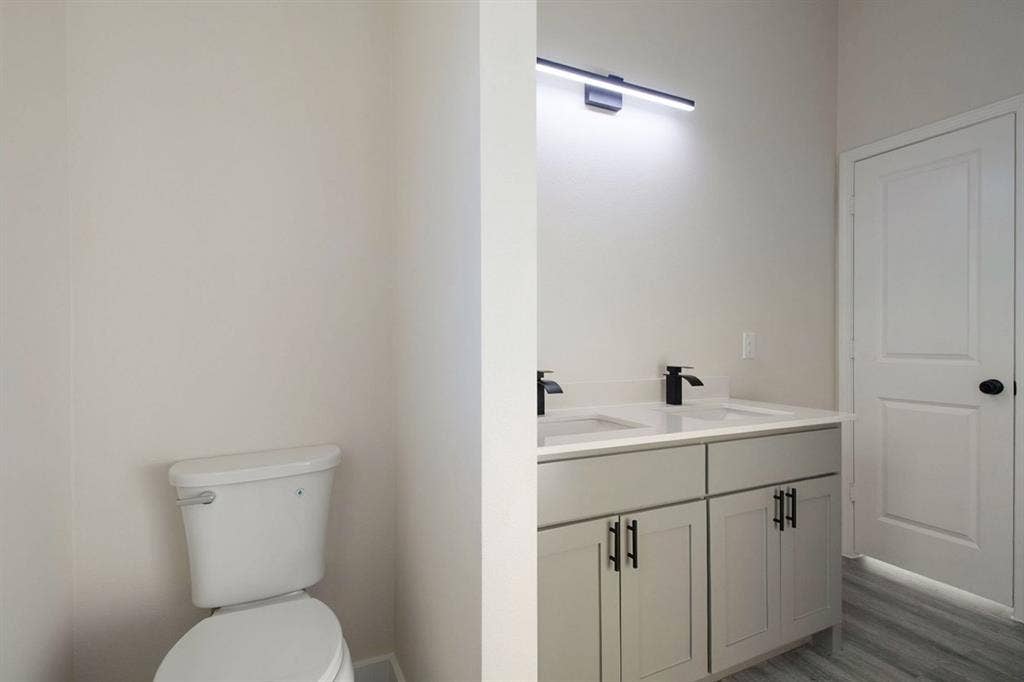 Dual vanity with matte black faucets, light gray cabinetry, and a light-toned countertop