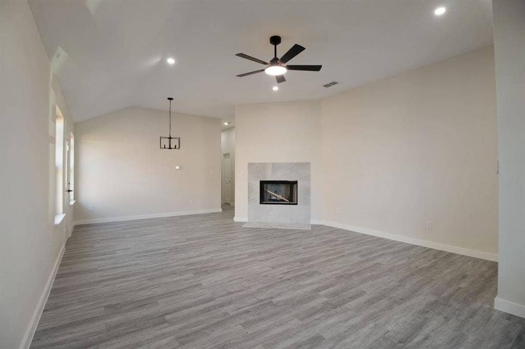 Vaulted ceilings, recessed lighting, and a modern ceiling fan illuminate this expansive room