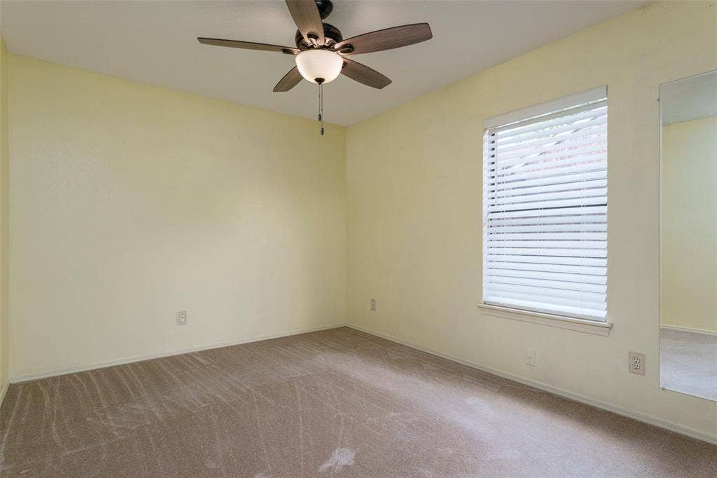 826 Camino Court, Grand Prairie, TX 75052 Room featuring a ceiling fan with integrated lighting, neutral wall-to-wall carpeting, and a window fitted with horizontal blinds