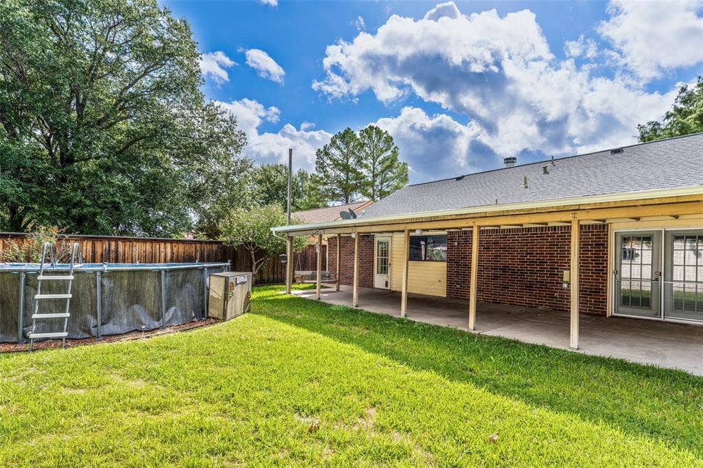 826 Camino Court, Grand Prairie, TX 75052 Brick exterior with an expansive covered patio, partially fenced backyard, and above-ground pool