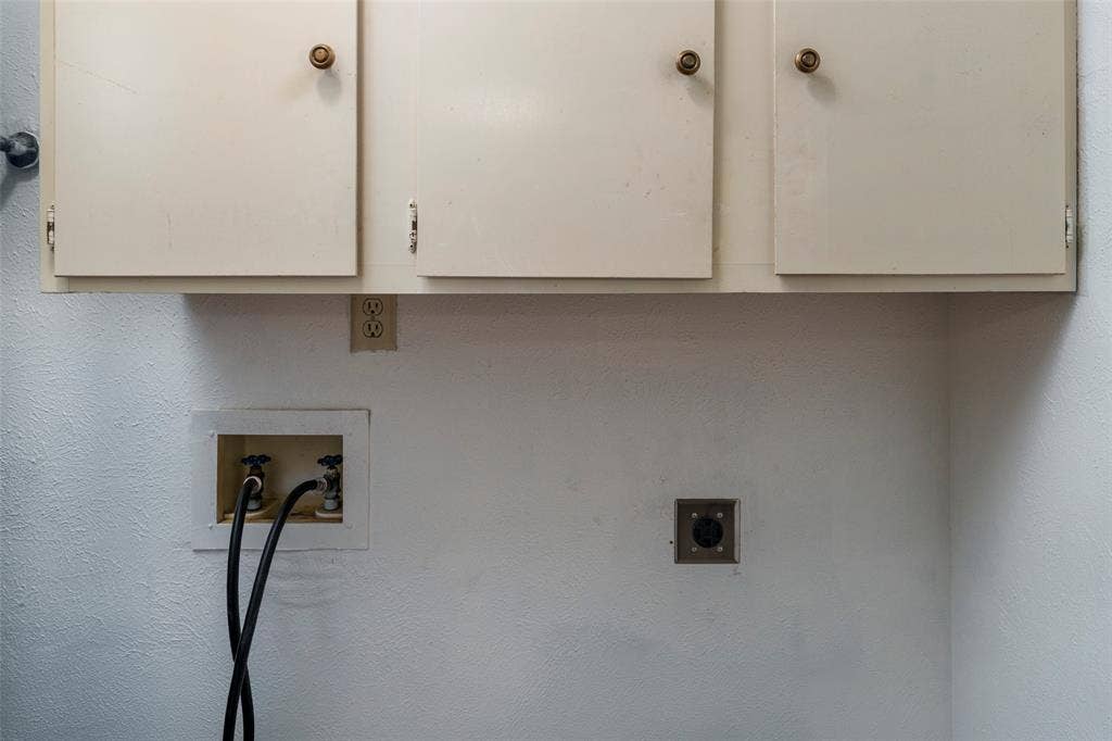 826 Camino Court, Grand Prairie, TX 75052 Built-in upper cabinetry with round hardware, recessed water supply valves, and a dedicated 240-volt electrical outlet