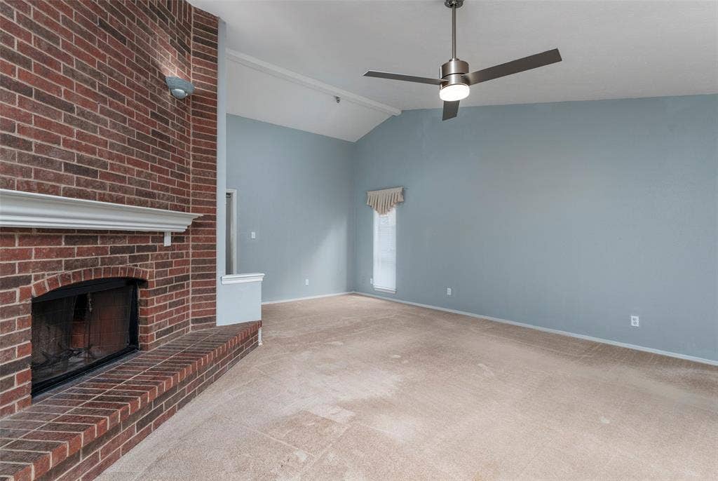 826 Camino Court, Grand Prairie, TX 75052 Vaulted ceiling featuring a brick fireplace with a white mantel and a metal ceiling fan