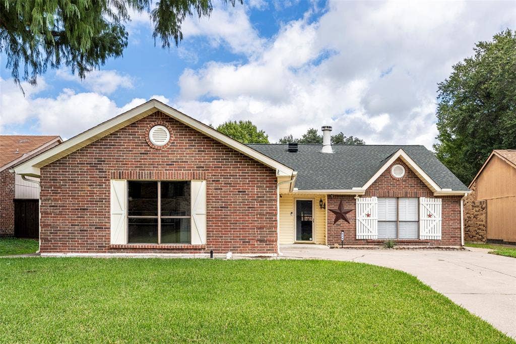 826 Camino Court, Grand Prairie, TX 75052 Brick exterior featuring white louvered shutters, shingled roofing, and a concrete driveway